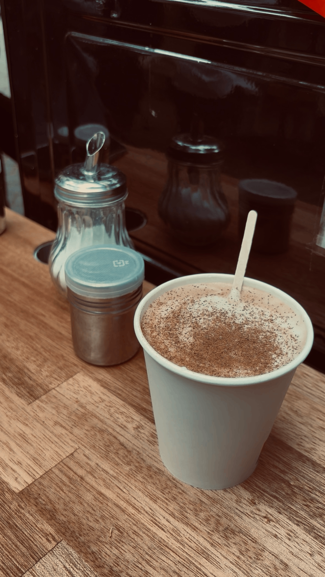Cappuccino dusted with cocoa on a wooden counter