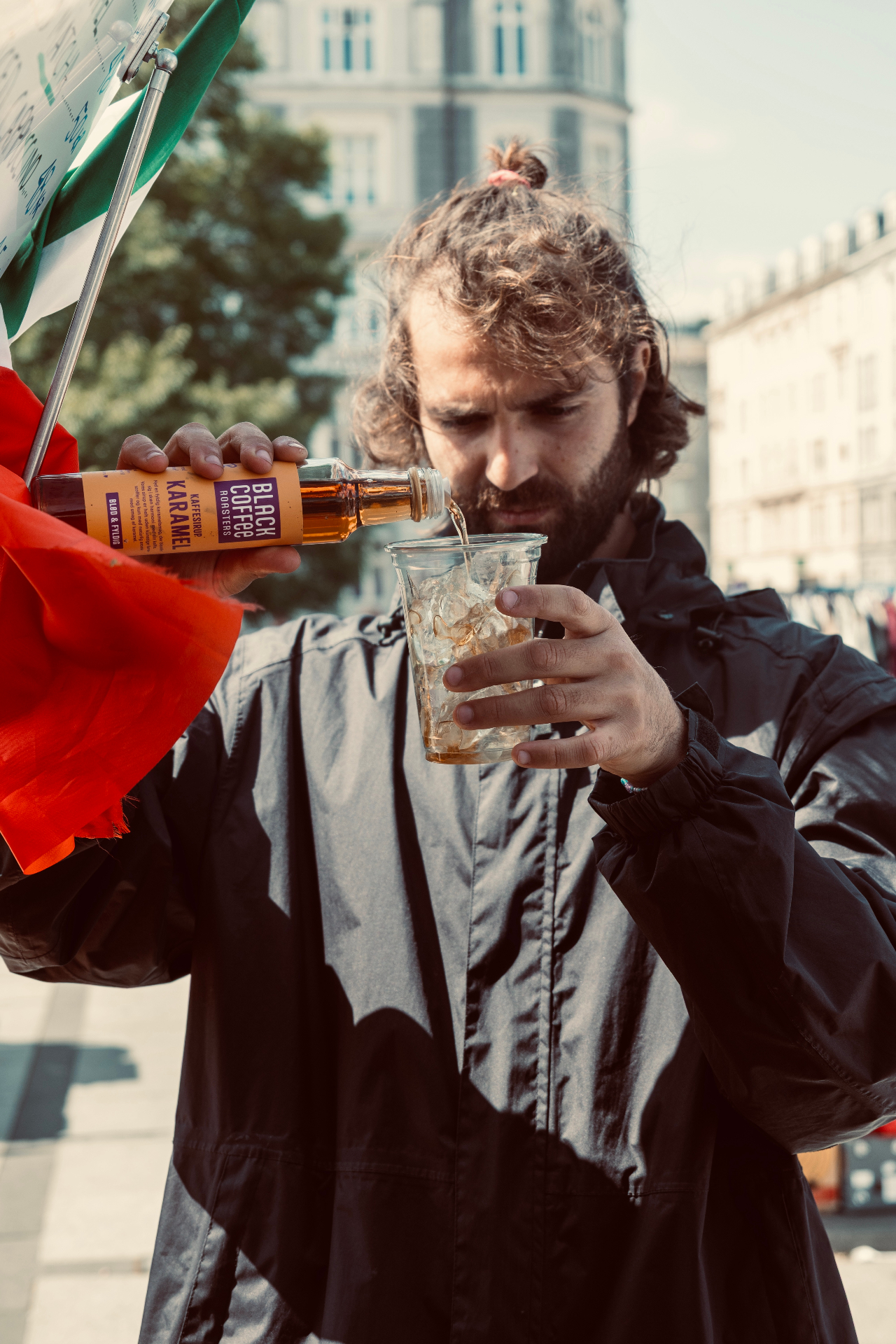 Pouring caramel syrup into an iced coffee