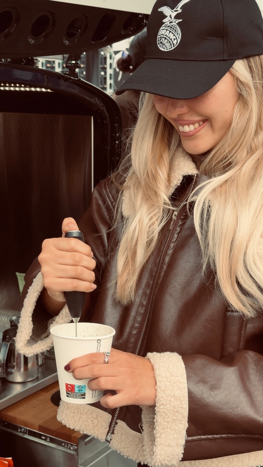 Barista frothing milk inside the coffee van